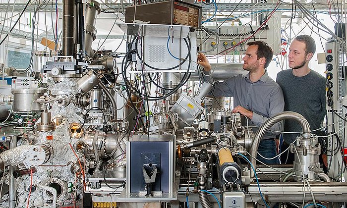 Andrew Crampton und Marian Rötzer an ihrer Vakuum-Anlage zur Herstellung ultrakleiner Katalysatorpartikel - Foto: Andreas Heddergott / TUM