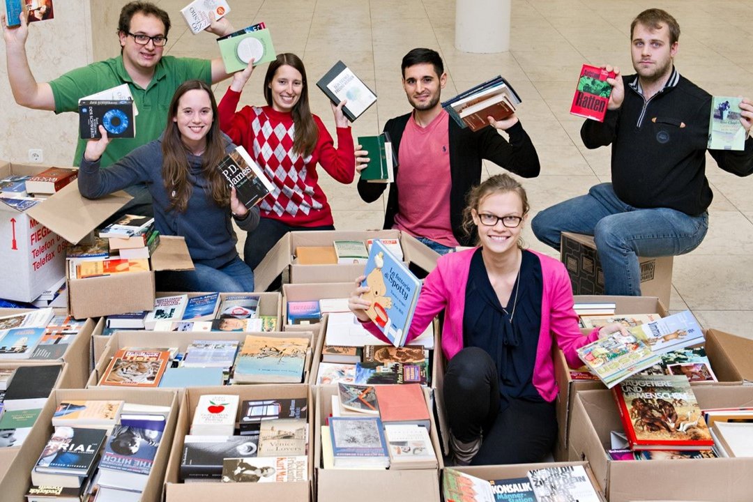 Studierende mit Kisten voller gespender Bücher