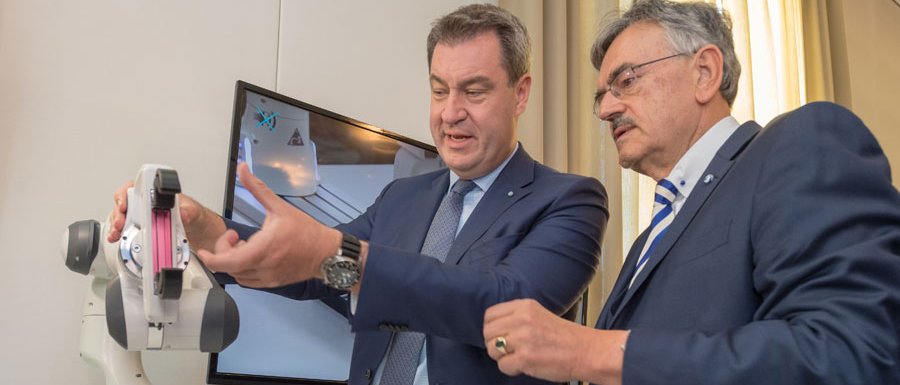 TUM-Präsident Wolfgang A. Herrmann (r.) zeigt Ministerpräsident Markus Söder einen Roboterarm, der Physiotherapeuten entlasten soll. (Bild: A. Heddergott / TUM)