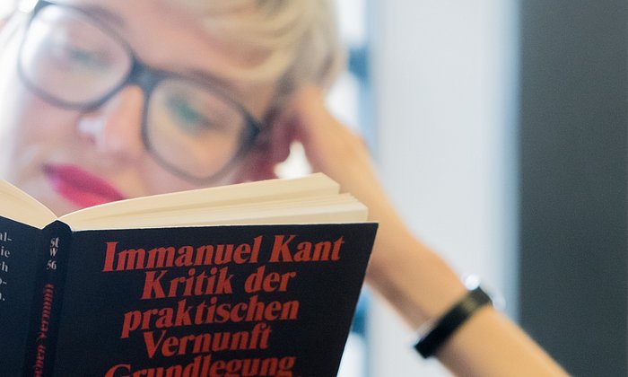 Student reading a book of Immanuel Kant