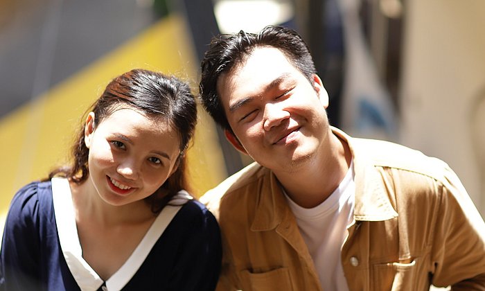 Zwei asiatischstämmige Studierende lächeln den Betrachter an.