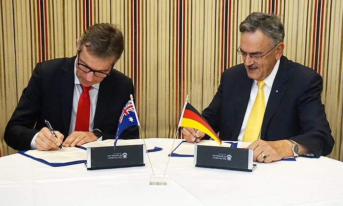 Prof. Peter Høj, Präsident der University of Queensland (links), und  TUM-Präsident Prof. Wolfgang A. Herrmann unterzeichnen die Kooperationsvereinbarung.