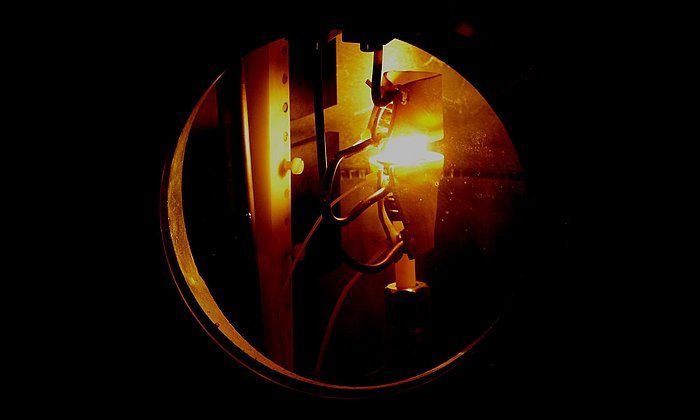 Ein glühender Metalltropfen schwebt zwischen zwei Spulen im Neutronenstrahl. (Foto: Andrea Voit/TUM)