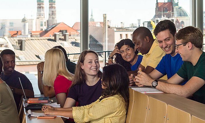 Studierende in einem Hörsaal mit Blick auf die Münchner Frauenkirche