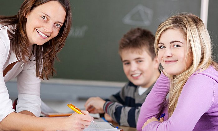 Eine Lehrerin mit zwei Schülern im Mathematikunterricht