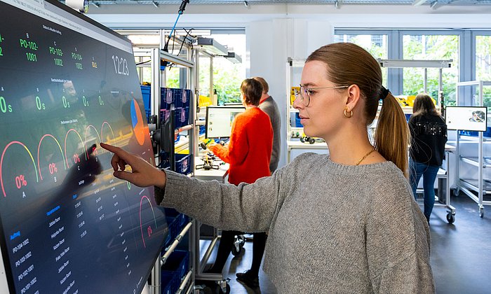 Lehramtsstudentin Lisa Teichmann steuert über den Touchscreen eine volldigitalisierte Produktionsanlage.