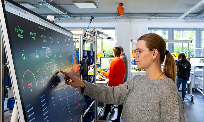 Pre-service teacher Lisa Teichmann controls a fully digitized production system via the touchscreen.