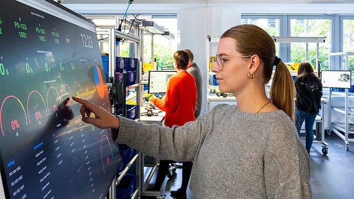 Pre-service teacher Lisa Teichmann controls a fully digitized production system via the touchscreen.