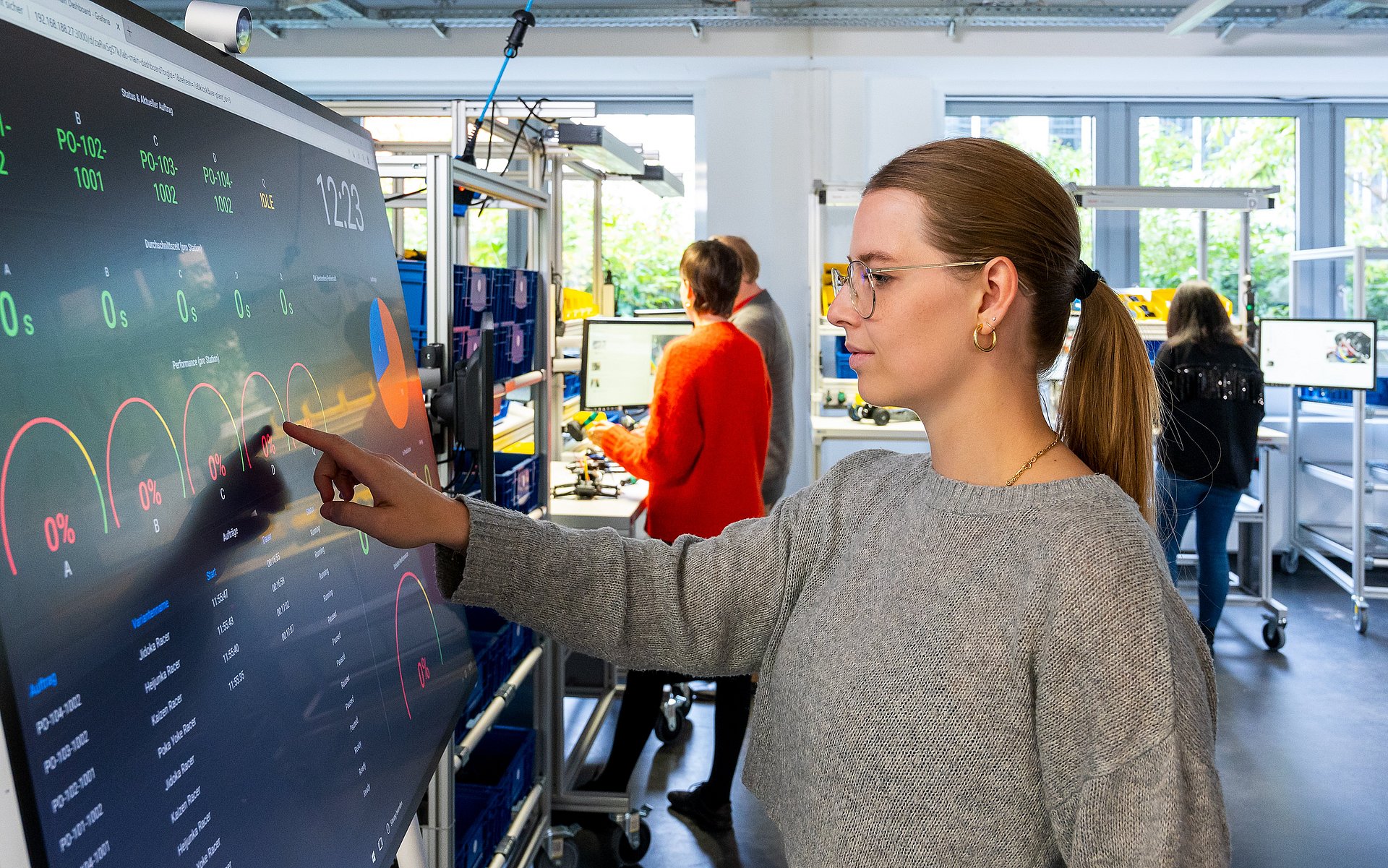 Pre-service teacher Lisa Teichmann controls a fully digitized production system via the touchscreen.