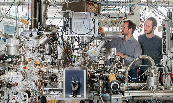 Andrew Crampton and Marian Rötzer at their vacuum chamber for production of ultra-small catalyst particles - Photo: Andreas Heddergott / TUM