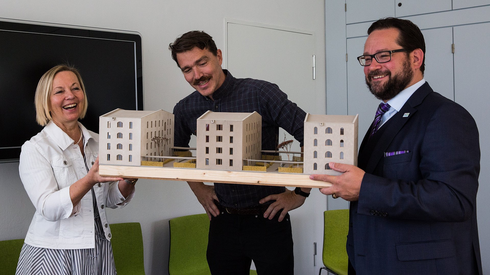 Dr. Ursula Wurzer-Faßnacht, Architekt Tilmann Jarmer und Alexander Bonde (v.l.n.r.) mit einem Modell der Häuser in Garching.