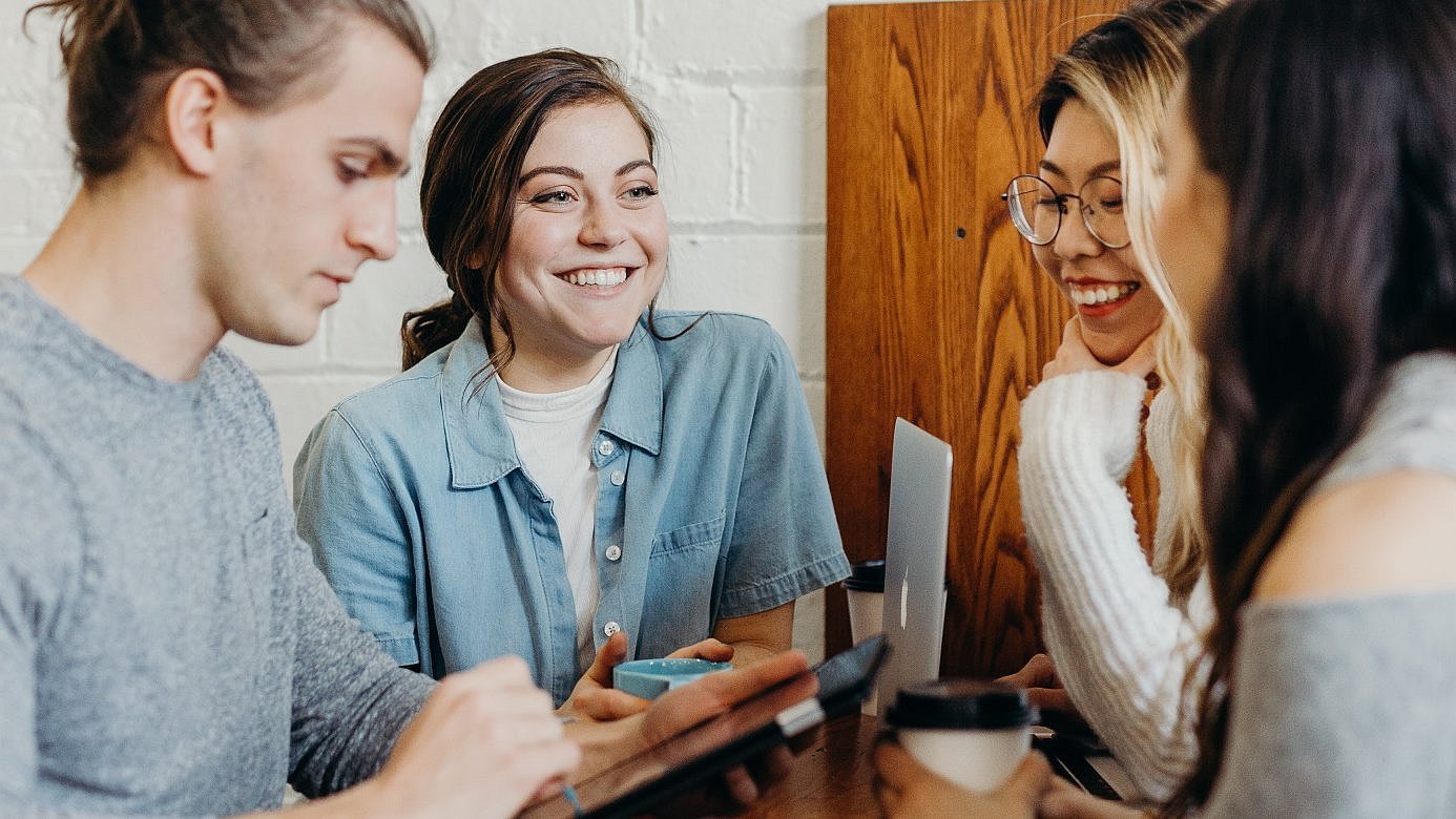 A man and three women talking