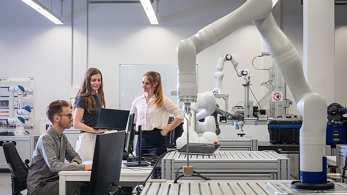 Wissenschaftlerinnen und Wissenschaftler in einem Robotik-Labor der TUM.