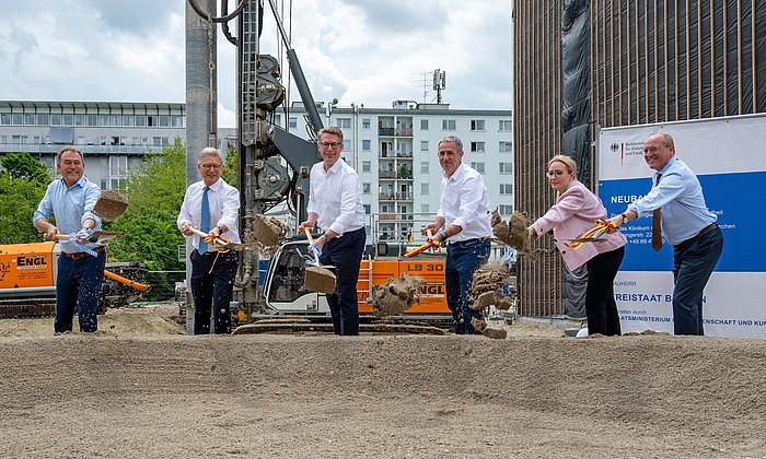 The speakers break ground for the building.