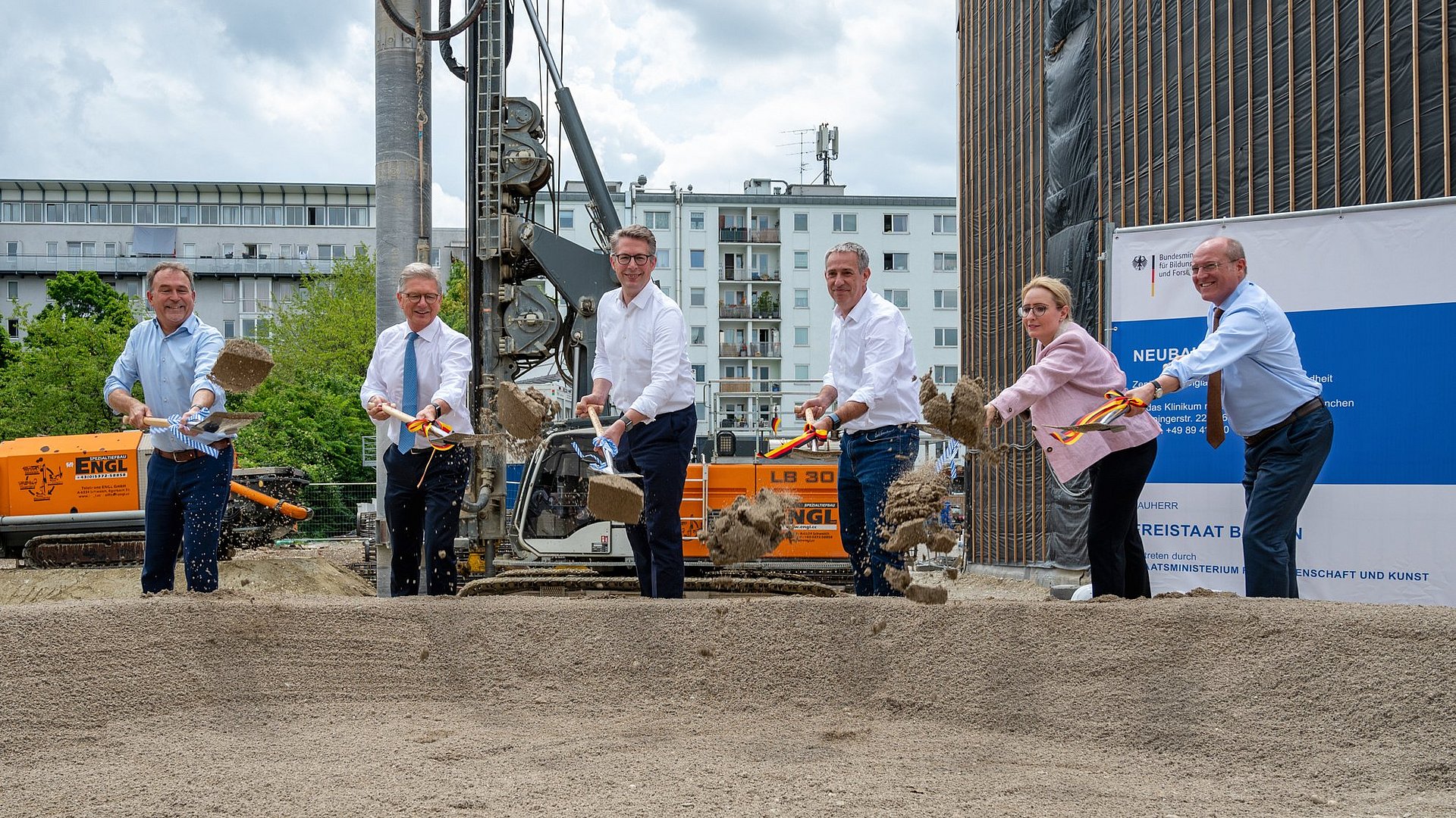 Die Rednerinnen und Redner setzen den ersten Spatenstich für das Gebäude. Die Rednerinnen und Redner setzen den ersten Spatenstich für das Gebäude.