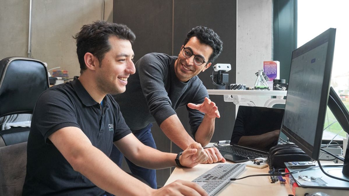 Two team members of a robotics startup at a computer in the Robotics/AI Venture Lab.