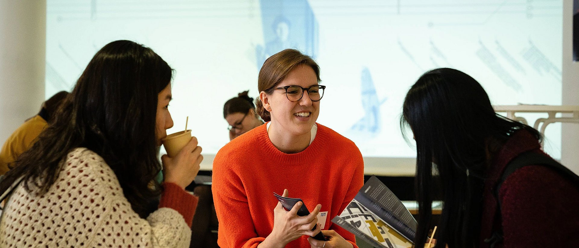 Three female participants have an animated conversation at the TUM4Mind Action Day 2018.