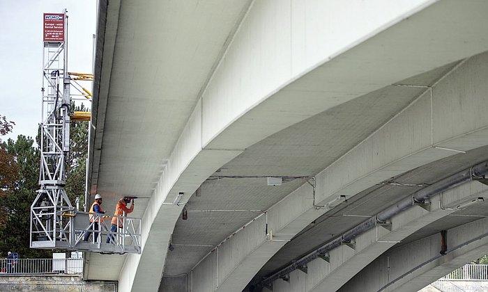 Two researchers install ultrasonic sensors on the underside of the Gänstor Bridge between Ulm and Neu-Ulm 