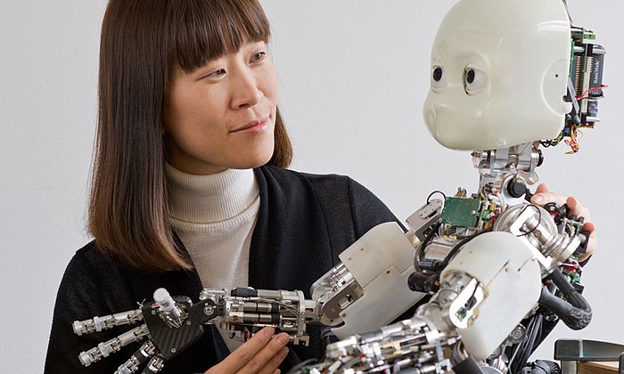 Prof. Dongheui Lee in ihrem Labor mit einigen Robotermodellen.