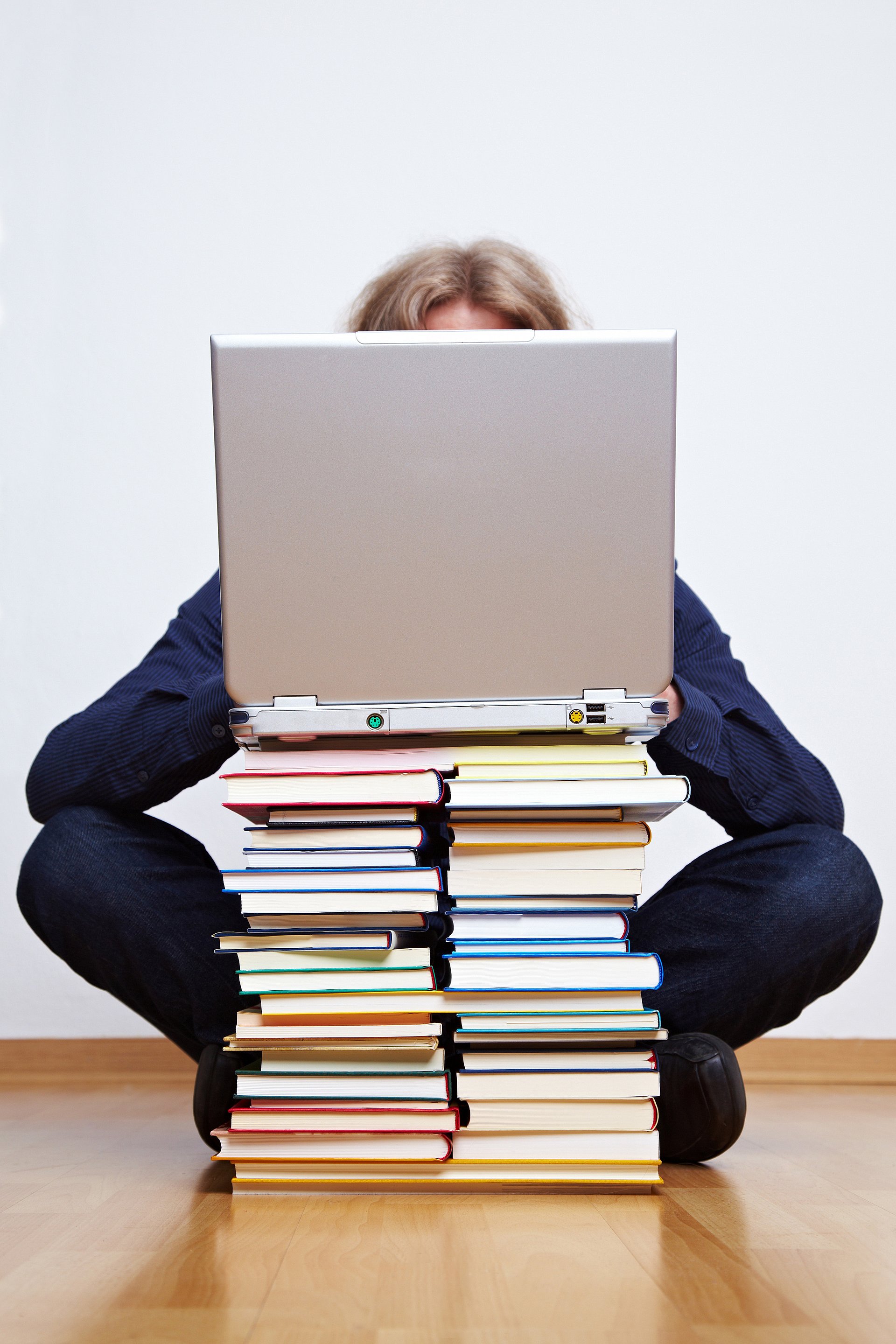 Geöffneter Rechner auf Bücherstapel Geöffneter Rechner auf Bücherstapel