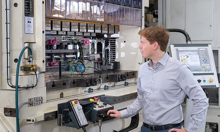 Hannes Weiss am Stanzautomaten. An dieser Maschine schneiden die Wissenschaftler die Elektrobleche mithilfe komplexer Werkzeuge.