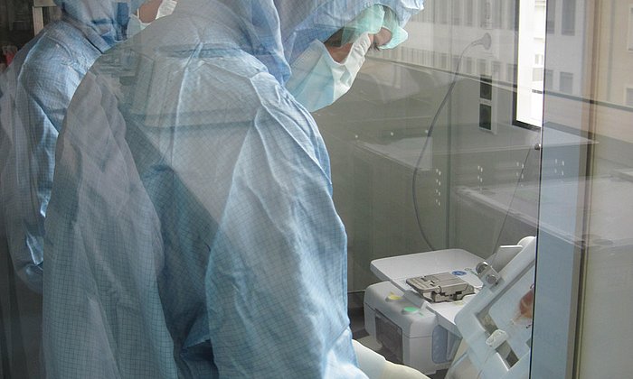 As work with cells requires highly-pure working conditions, the scientists wear sterile clothing in the clean rooms. (Photo: M. Neuenhahn / TUM)