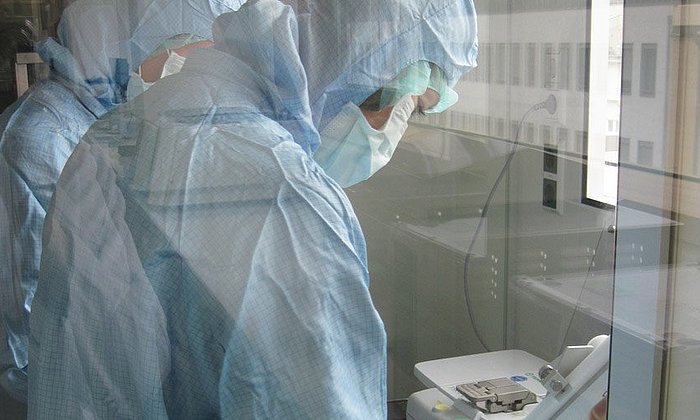 Weil die Arbeit mit Zellen hochreine Bedingungen erfordern, tragen die Mitarbeiter in den Reinräumen sterile Bekleidung. (Foto: M. Neuenhahn / TUM)