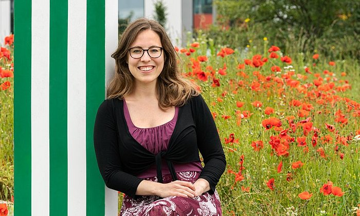 Michaela Wilfling in front of a field with poppies 