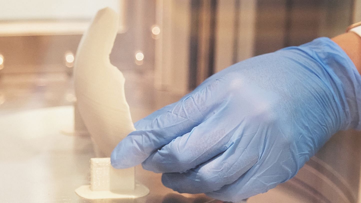 Close-up of an implant held by a woman wearing gloves