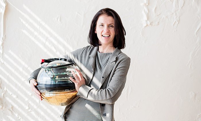Prof. Elisa Resconi with one of the photo-detectors used in the IceCube observatory. (Picture: Magdalena Jooß / TUM)
