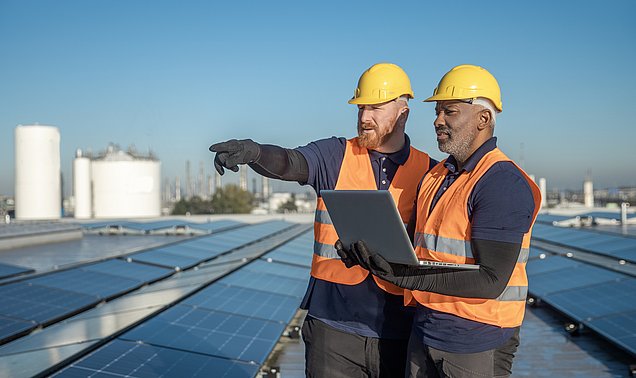 Zwei Ingenieure begutachten eine Photovoltaik-Anlage.