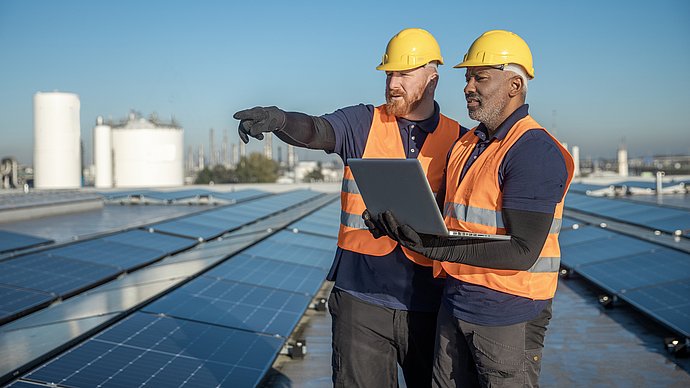 Zwei Ingenieure begutachten eine Photovoltaik-Anlage.