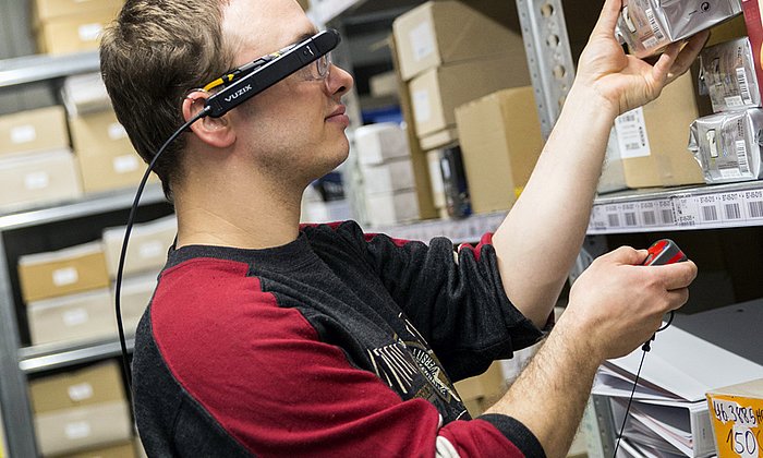 Marc Pulz, Mitarbeiter im Bereich Kommissionierung bei der Schmaus GmbH, nutzt die Datenbrille bei seiner Arbeit.