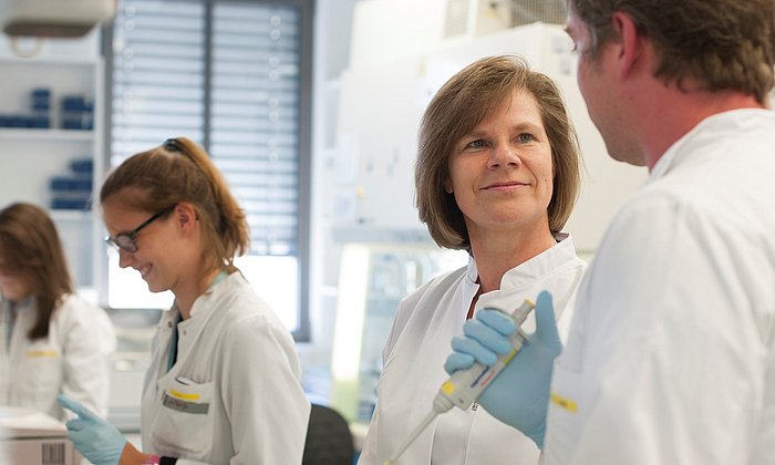 Prof. Ulrike Protzer mit Mitarbeitenden im Labor.