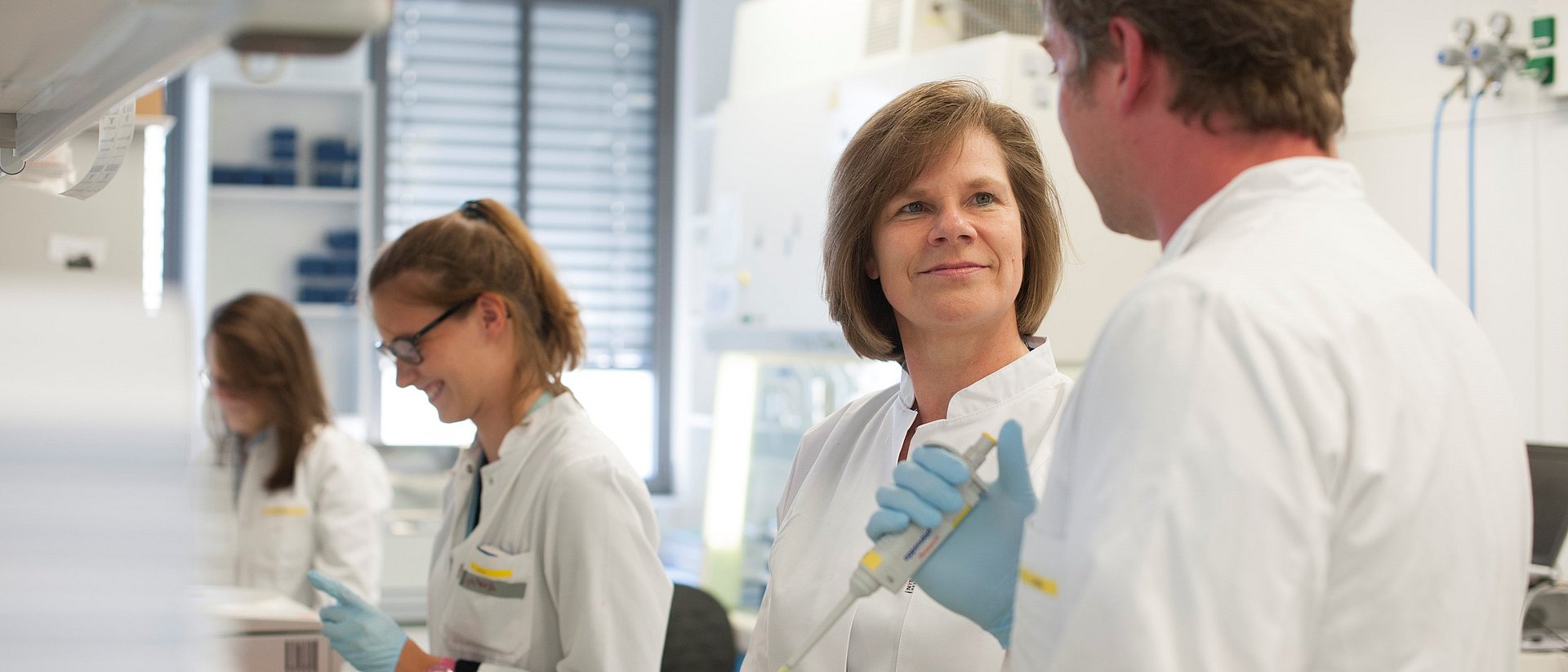 Prof. Ulrike Protzer with colleagues in the laboratory.