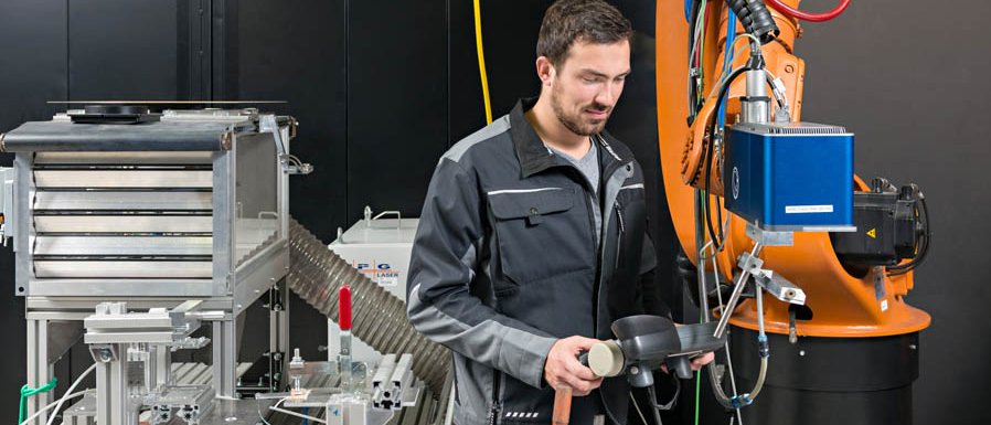André Heckert, wissenschaftlicher Mitarbeiter am iwb, positioniert den Laser für die Bearbeitung des Metalls für das Fügen von Metall- Kunststoff-Verbindungen.