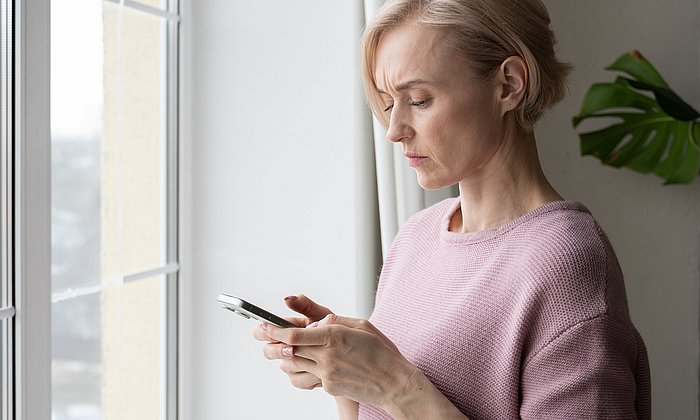 Eine Frau schaut auf ein Smartphone