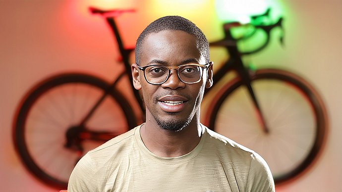 Porträtfoto von Emmanuel Adjei, im Hintergrund ein illuminiertes Fahrrad