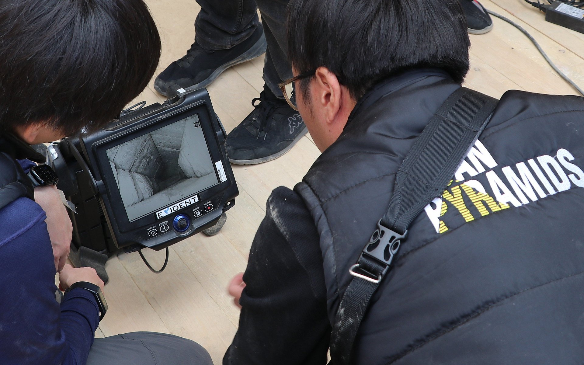 Researchers stand around the screen of an endoscope.