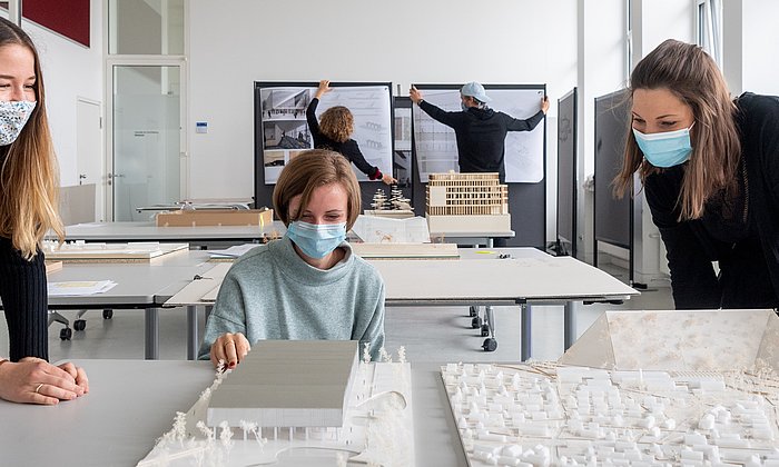 Architektur-Studierende mit Modellen.