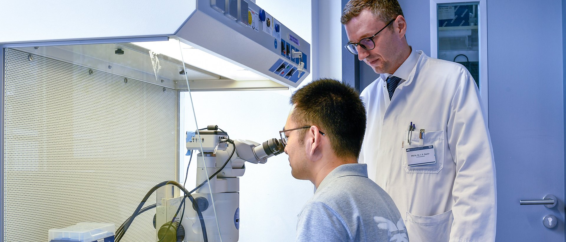 Ein Mitarbeiter von Dr. Ekin Demir (rechts) isoliert  sensorische Nervenzellen (Neuronen) unter einem Stereomikroskop.