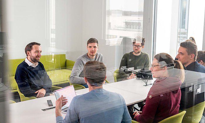 Prof. Stephan Günnemann (links) im Gespräch mit Doktorand:innen am Munich Data Science Institute.