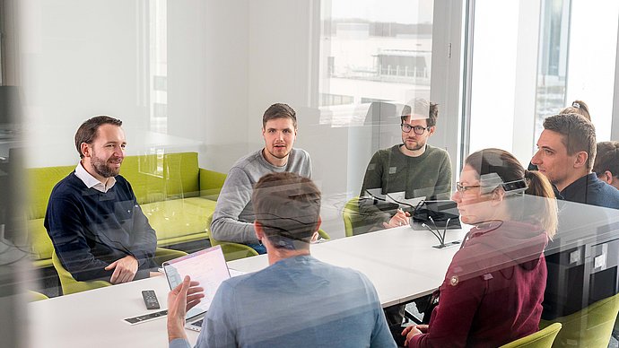 Prof. Stephan Günnemann (links) im Gespräch mit Doktorand:innen am Munich Data Science Institute.