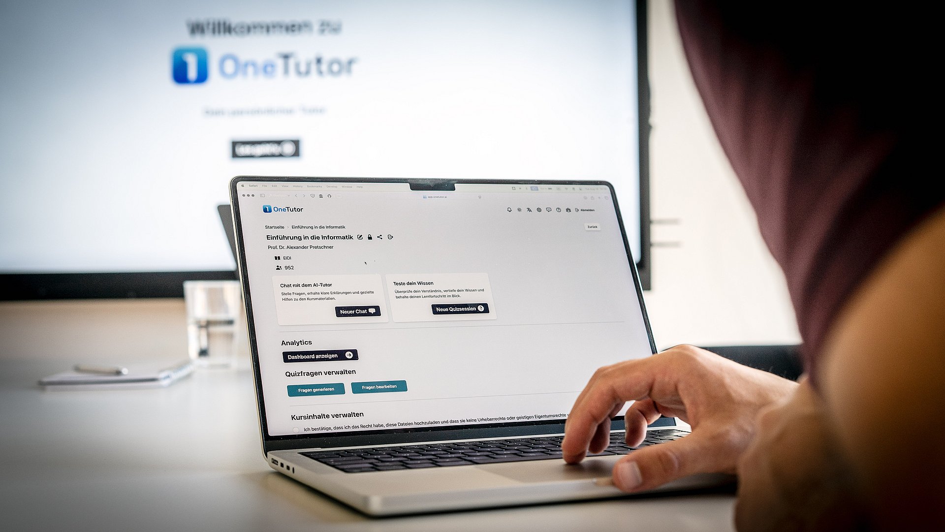 A look over the shoulder of a student who is sitting at a PC and working with the OneTutor tool.