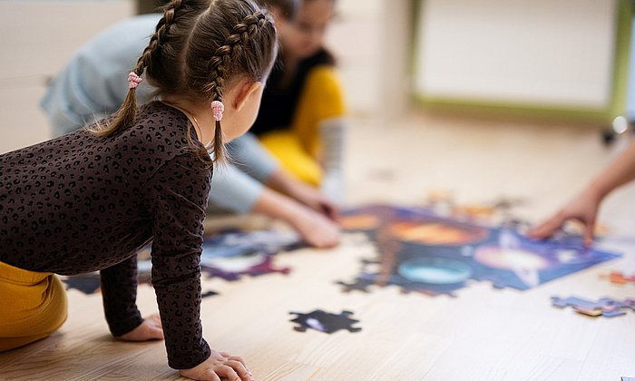 Kleinkinder spielen mit einem Puzzle.