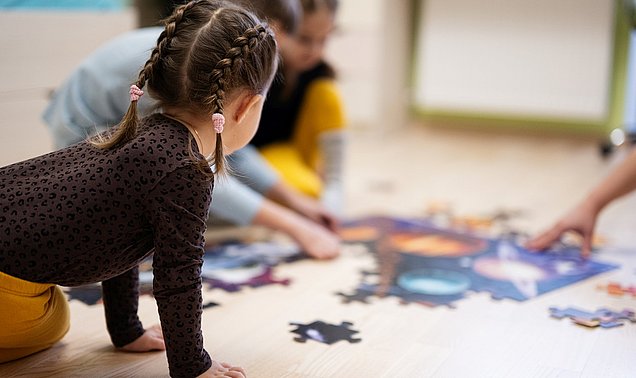 Kleinkinder spielen mit einem Puzzle.