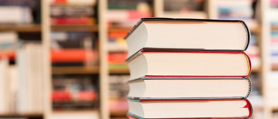 Stack of books in front of a bookshelf