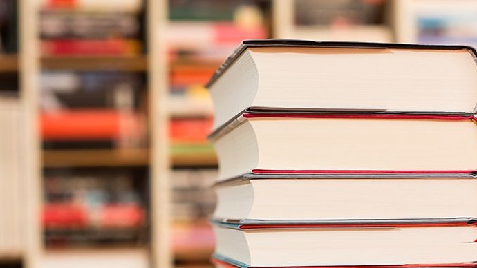 Stack of books in front of a bookshelf