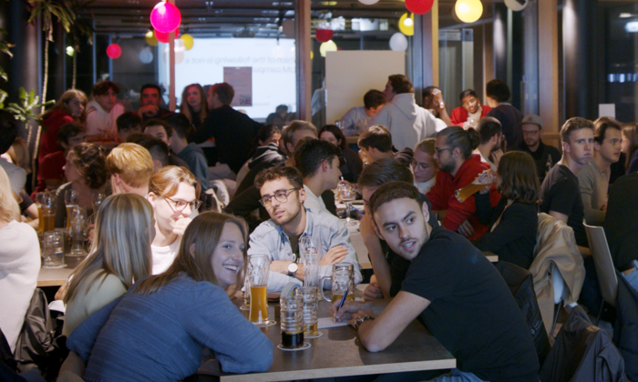 Students at tables in the Campus Cneipe at the Garching campus, where they participate in a pub quiz organized by ESN TUMi.