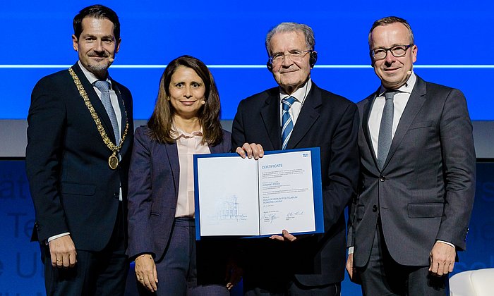 Romano Prodi with TUM President Thomas F. Hofmann (l.), Dean Gunther Friedl (r.), and Eugénia da Conceição-Heldt on stage in the audimax lecture hall.